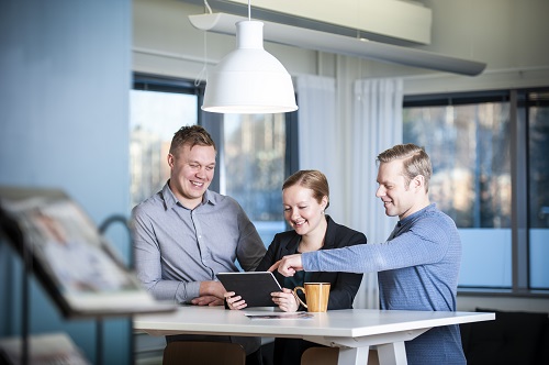 Buildercomin asiantuntijat kahvihuoneessa katsomassa tablettia